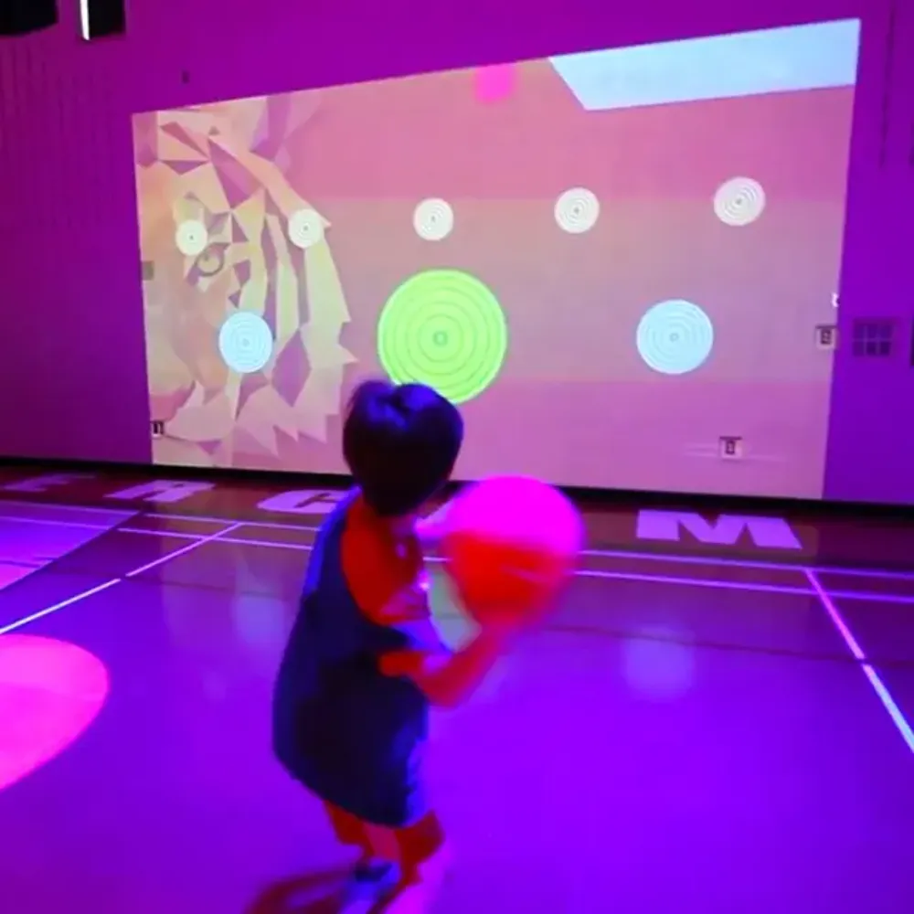 Enfant Jouant Le Jeu Interactif Projeté Au Mur. Concept De Jeux De